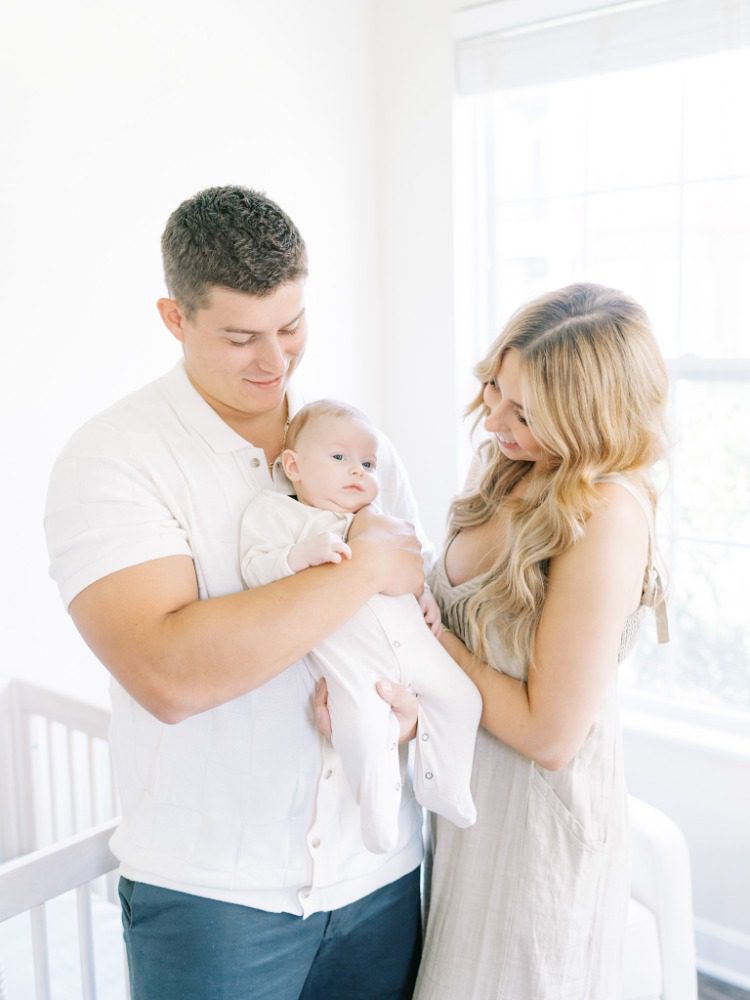 Mom and dad holding young baby in his nursery during their photoshoot with family photographer in crestwood, ky